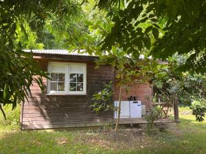 a small house with a window and a refrigerator at Ti Bwa in Sainte-Luce