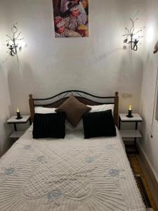 a bedroom with a large bed with two night stands at Riad dar khadija in Taroudant +5 photos
