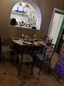 a table and chairs in a kitchen with a mirror at Riad dar khadija in Taroudant