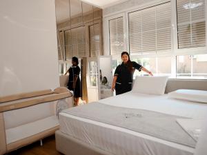 a woman standing next to a bed in a room at Ingrit Gjoni Villas in Draç