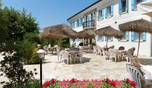 卡瓦利諾－特雷波爾蒂的住宿－多爾恰誇農莊酒店，一个带桌椅和稻草遮阳伞的庭院