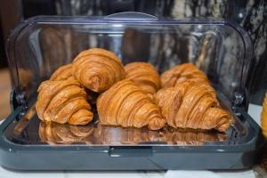 a bunch of croissants in a glass container at Hotel MANAMI in Prishtinë