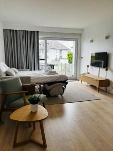 a bedroom with a bed and a couch and a table at Cozy Studio with Pool in Middelkerke 4 Guests in Middelkerke