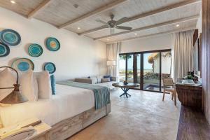 a bedroom with a bed and a living room with a patio at Mystique Holbox by Royalton, A Tribute Portfolio Resort in Holbox Island