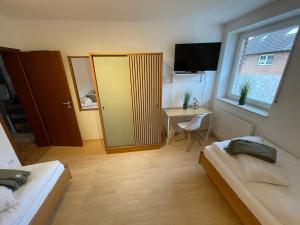 a bedroom with two beds and a desk and a window at Fewo Auenblick in Ascheberg
