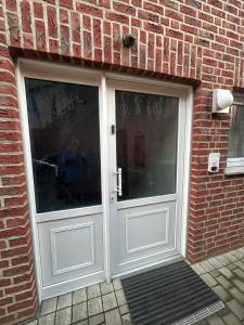 a white door in a brick building with a brick wall at Fewo Auenblick in Ascheberg