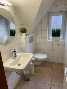 a white bathroom with a sink and a toilet at Fewo Auenblick in Ascheberg +6 photos
