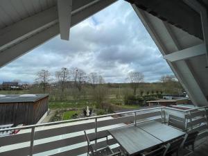 a balcony with a table and chairs and a field at Fewo Auenblick in Ascheberg