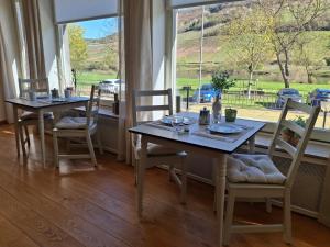 a dining room with two tables and chairs and a window at B&B Haus Valmosa in Valwig