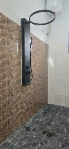 a bathroom with a shower with a tiled wall at Hôtel Belvédère in Toliara