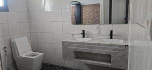 a bathroom with two sinks and a toilet at Hôtel Belvédère in Toliara