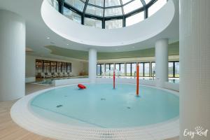 a large pool in a building with a glass ceiling at Prestige 113 - tuż przy plaży, z widokiem na morze, parkingiem i WiFi w cenie pobytu - Easy-Rent Apartments in Pobierowo
