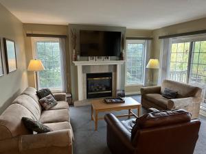 a living room with two couches and a fireplace at Sunny Days at Shanty Creek in Bellaire +20 photos