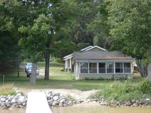 a house with a car parked in front of it at Sandy Bottom Cottage on Intermediate Lake in Bellaire