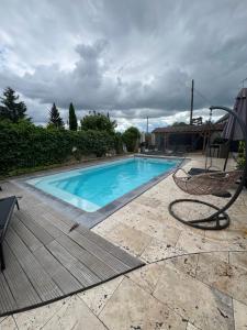 a large swimming pool with a chair and a chair at Le Val Cosy in Montlivault +1 photo