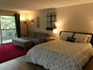 a bedroom with a bed and a couch at Happy Hour at Windcliff! Studio condo at Shanty Creek Resort in Bellaire