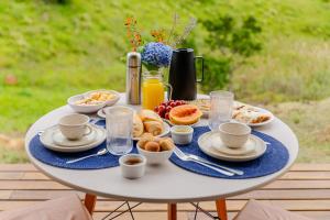 a white table with breakfast foods on it at Morada do Valle Chalés in Timbe do Sul