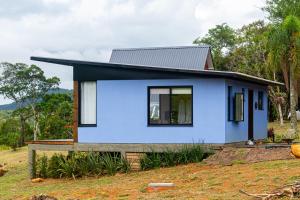 a blue house with a black roof at Morada do Valle Chalés in Timbe do Sul