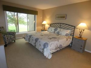 a bedroom with a bed and two lamps and a window at Courtside Condo at Summit in Bellaire