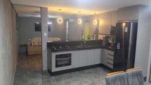 a kitchen with a sink and a refrigerator at Refúgio Beira-Mar in Itanhaém