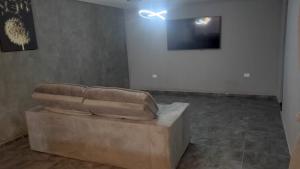 a brown couch sitting in a room with a wall at Refúgio Beira-Mar in Itanhaém