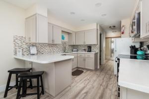 a kitchen with white cabinets and a counter and stools at Cavalier Condos #32 in Lincoln City