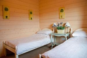 two beds in a room with a table and two lamps at Skylark Lodge in Dumfries