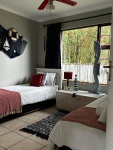 a bedroom with two beds and a window at African Sun Guest House in Molen Drift