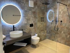 a bathroom with a toilet and a sink and a mirror at Unterlechnerhof in Vollan +17 photos