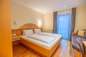 a bedroom with a large bed and a couch at Haus Dorfblick in Filzmoos