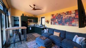 a living room with a blue couch and a kitchen at Bison Farm - Cabin "Vista" in Culpeper