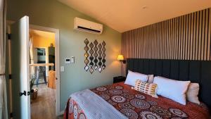 a bedroom with a bed with a red blanket and pillows at Bison Farm - Cabin "Vista" in Culpeper
