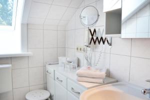 a white bathroom with a sink and a mirror at Forest Monteurzimmer & Fewo für Firmen & Gruppen in Bad Bevensen +34 photos