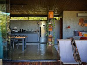 a kitchen with a refrigerator and a table with chairs at A nossa casa da arvore in Cavalcante +33 photos