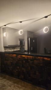 a bar in a room with three lights on it at Refúgio Beira-Mar in Itanhaém +2 photos