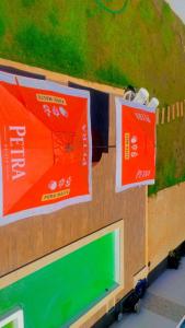 two signs on the side of a building with a greeninsula at Espaço Villa Manguinhos in São Francisco de Itabapoana +1 photo