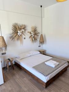 a bedroom with a bed and two pendant lights at Kanal Vstay #2 in Kithnos