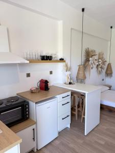 a kitchen with white cabinets and a white counter top at Kanal Vstay #2 in Kithnos +7 photos