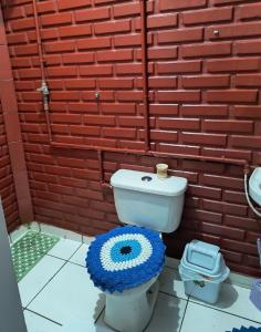 a bathroom with a toilet in front of a brick wall at Espaço Pires in Jaciara +13 photos