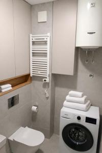 a bathroom with a toilet and a washing machine at Premium Rent Podgorica in Podgorica +2 photos