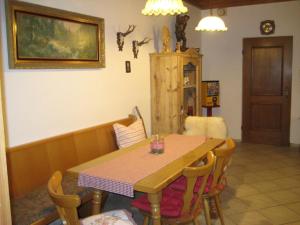 een eetkamer met een houten tafel en stoelen bij Pension zum Lusenblick in Mauth