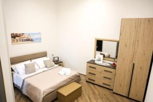a bedroom with a bed and a dresser with a mirror at Le Porte sulla Costiera in Sant'Egidio del Monte Albino