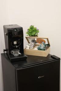 a coffee machine sitting on top of a black refrigerator at Le Porte sulla Costiera in Sant'Egidio del Monte Albino +16 photos