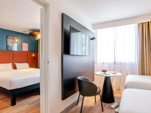 a hotel room with a bed and a small table at ibis Bordeaux Saint Emilion in Saint-Émilion +110 photos