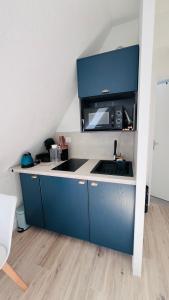 a kitchen with a sink and a microwave at Cabourg-Angle bleu in Cabourg