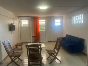 a living room with a blue couch and chairs at APPARTEMENT AMARYLLIS à 3 min de la PLAGE Pointe Marin in Sainte-Anne