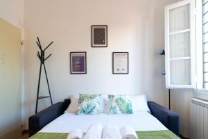 a room with a bed with a blue couch at Titina Apartment Novoli Close to Center & Airport in Florence