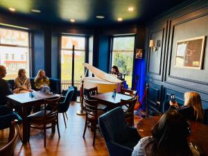 a group of people sitting at tables in a restaurant at The Great Western B&B in Paignton