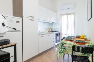 a kitchen with a table and a white refrigerator at Titina Apartment Novoli Close to Center & Airport in Florence