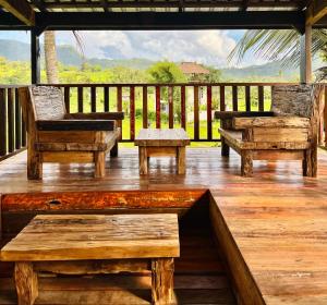 a deck with benches and a view of the mountains at Sawit House by Natural View in Karangasem